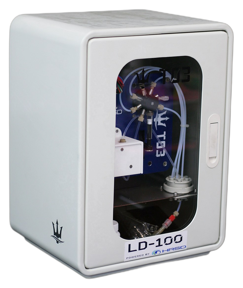 LD100 prototype: a compact white benchtop analyzer with a windowed front door, Powered by HRSD